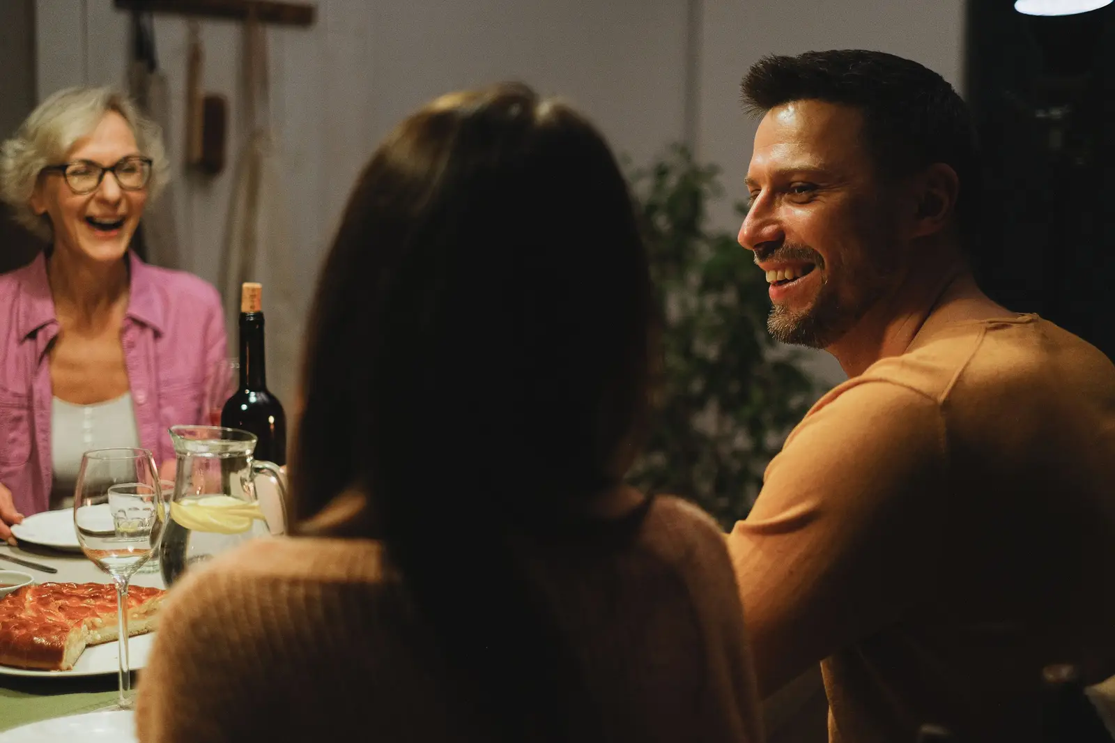 A family laughing over dinner at home in the evening